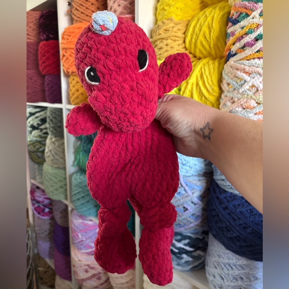 handmade Crochet red t-rex dinosaur knotted lovey with blue spikes.